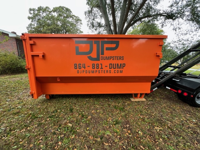 A 20-yard Space Saver dumpster on a lawn, taller walls visible